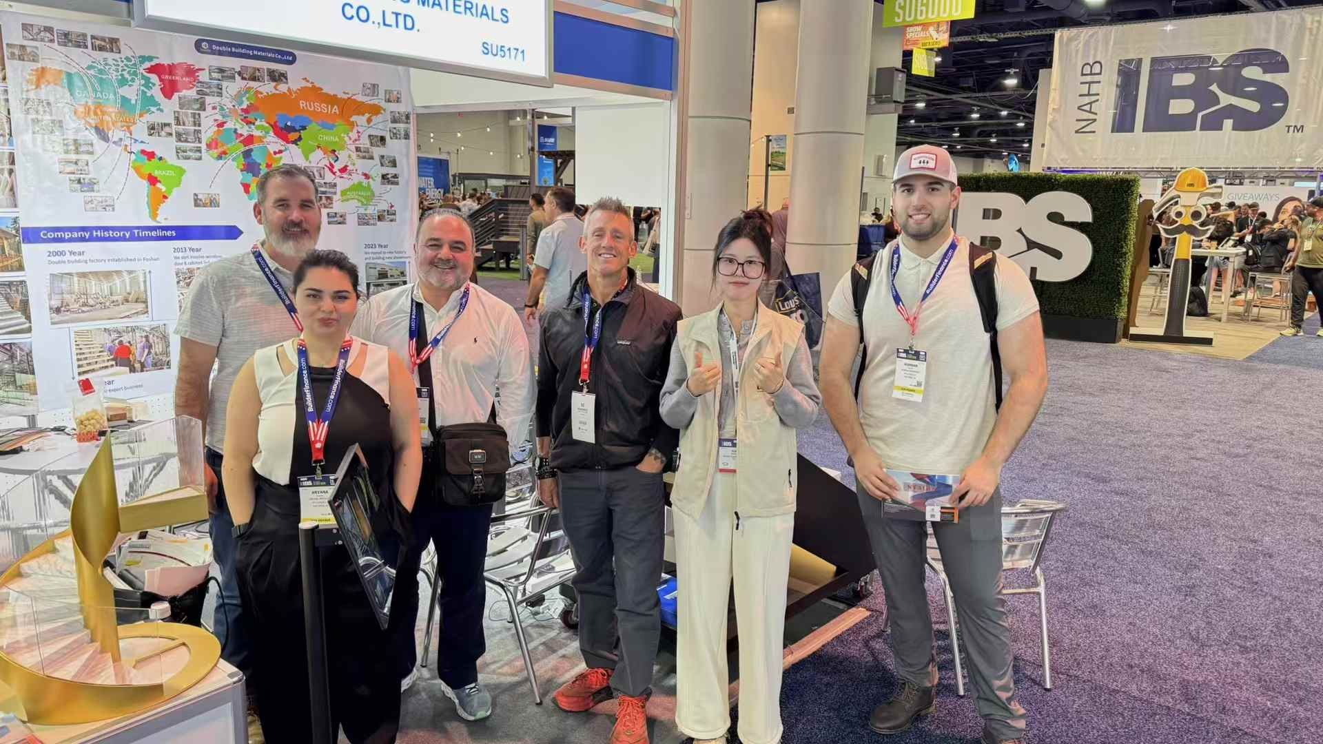 A group of US visitors and the Double Building Materials team photographed together at the IBS 2025 booth in Las Vegas