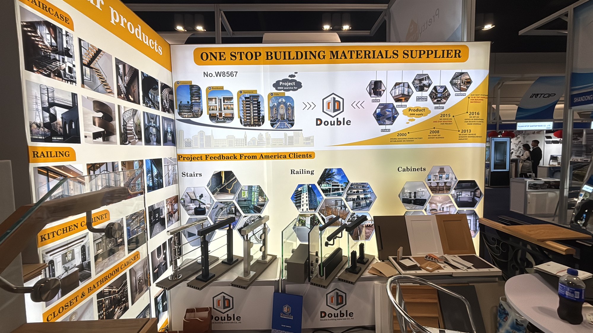 The Double Building Materials booth W8567 at IBS 2026, with a one-stop product banner, project photo walls and stair and railing samples on the counter