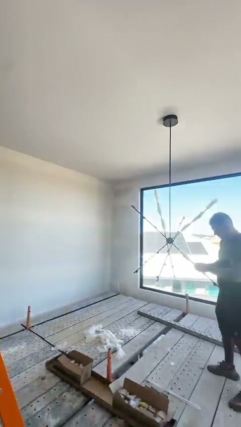Large dark-framed aluminium picture window during fit-out of the Adelaide new-build home, opening to the outdoor view