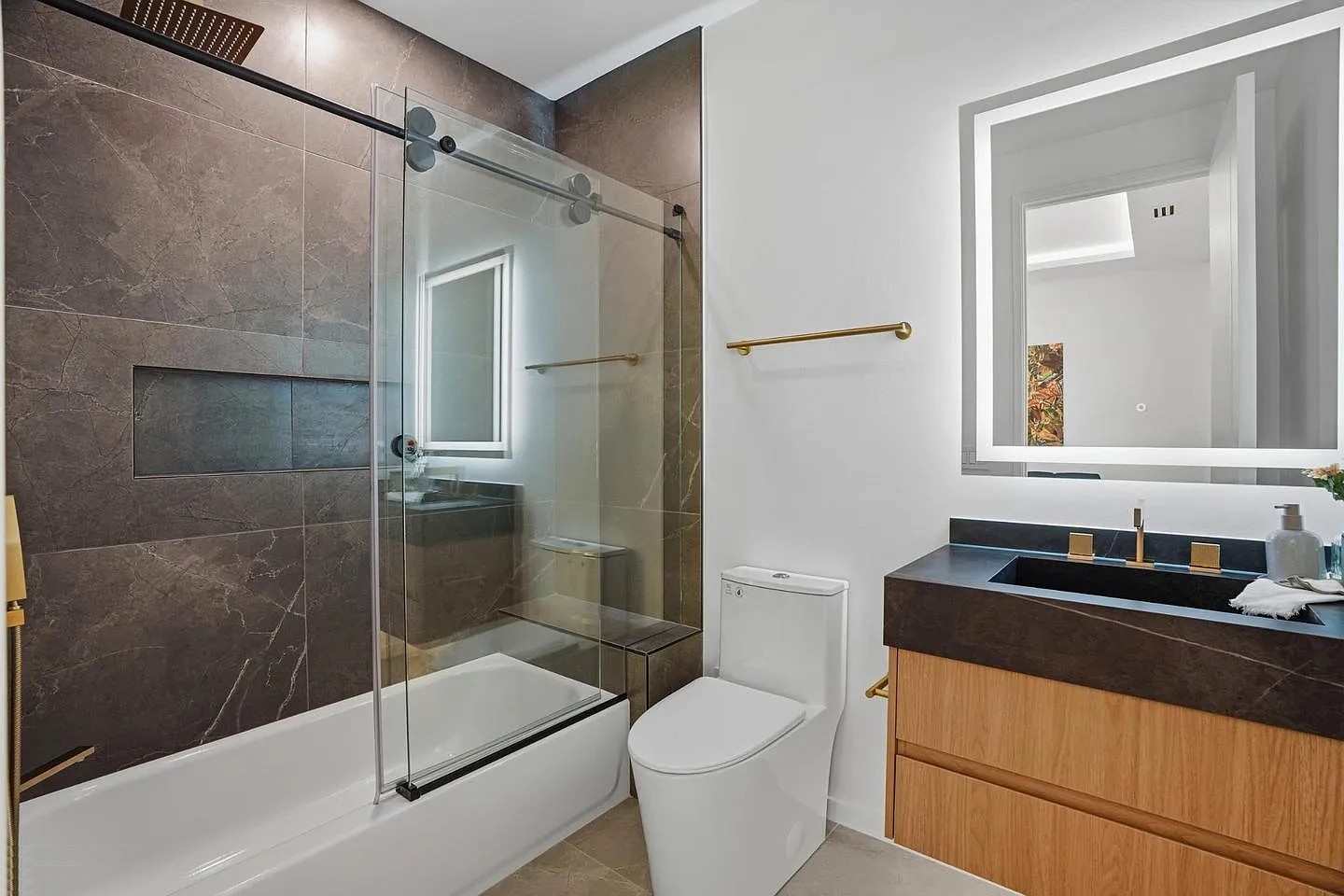 Sliding glass tub screen on a top bar with round rollers over a white bathtub in a modern Virginia bathroom
