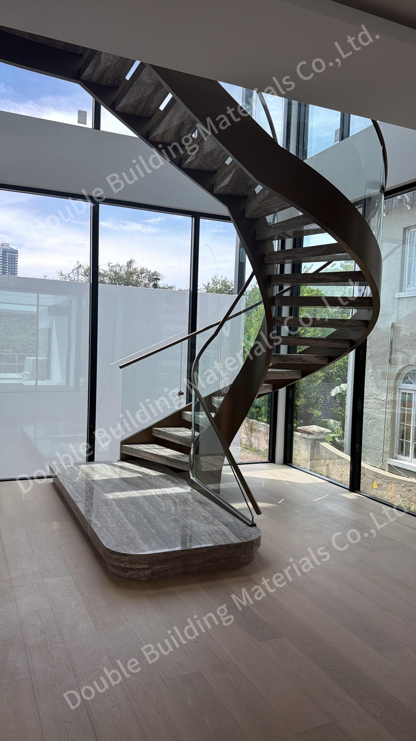 Curved double stringer staircase with brass-tone stringers, travertine treads and a glass balustrade on a stone plinth, Miami